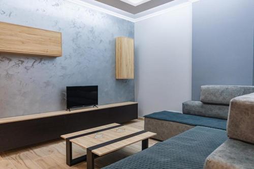 a living room with a tv and a couch at Holiday Apartment in Vlorë