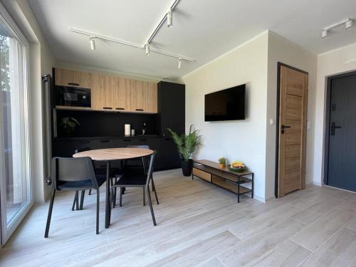 a kitchen and dining room with a table and chairs at Apartamenty przy Parku -150m od plaży in Darłówko