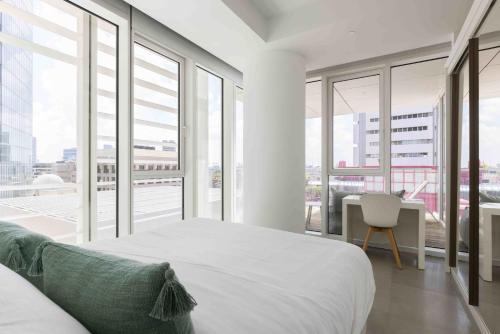 1 dormitorio con 1 cama, escritorio y ventanas en Exclusive Meier on Rothschild by Five Stay en Tel Aviv
