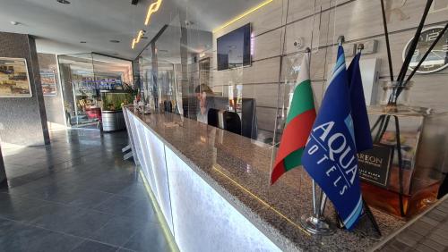 a bar in a restaurant with two flags at Aqua Hotel in Varna City