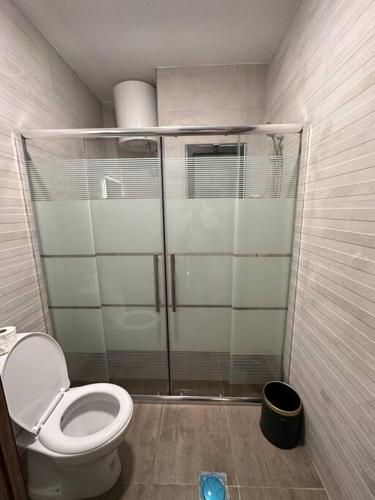 a bathroom with a toilet and a glass shower at modern apartment in abdoun-amman in Amman