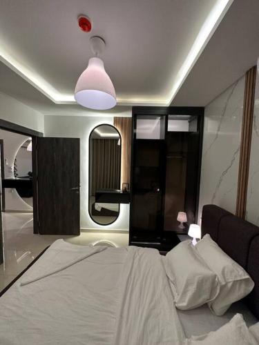 a bedroom with a bed and a large mirror at modern apartment in abdoun-amman in Amman