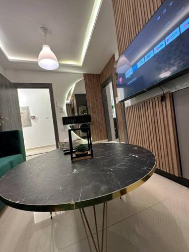 a black table in a room with a tv at modern apartment in abdoun-amman in Amman
