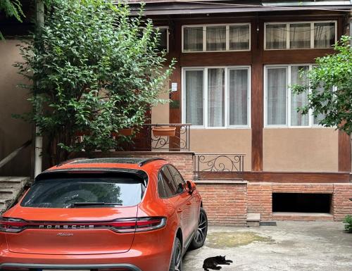 a car parked in front of a house with a cat at Lovely Apartment in Old Tbilisi in Tbilisi City