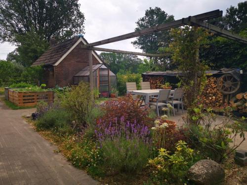 een tuin met een tafel en stoelen en een gebouw bij Trekkershut - Tiny House - Hikers cottage in Wijster