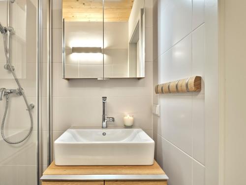 y baño con lavabo blanco y ducha. en Alpine Apartment Pia 6 - Bad Mitterndorf by AA Holiday Homes, en Bad Mitterndorf