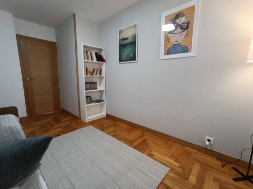 een woonkamer met een bank en een boekenplank bij Acogedor apartamento en Vigo in Vigo