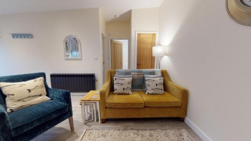 a living room with two chairs and a table at Primera Barn in Witney