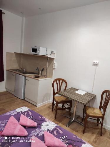 a kitchen with a table and two chairs and a table and a table at Hôtel Lyonnais in Nice
