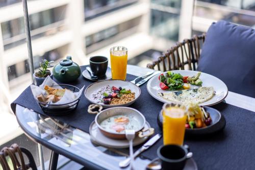 a table with plates of food and two glasses of orange juice at The Westin Istanbul Nisantasi in Istanbul