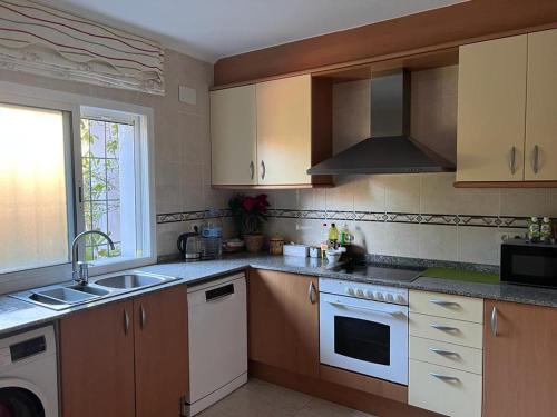 a kitchen with a sink and a stove at Villa Mont-roigh in Tarragona