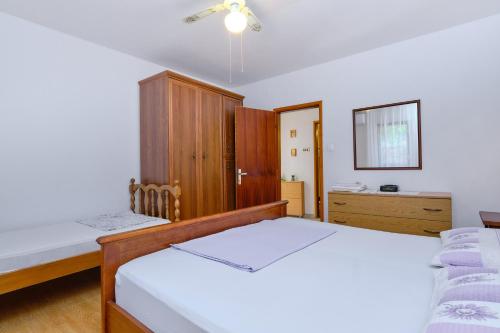 a bedroom with two beds and a dresser at Apartments Marija in Mali Lošinj