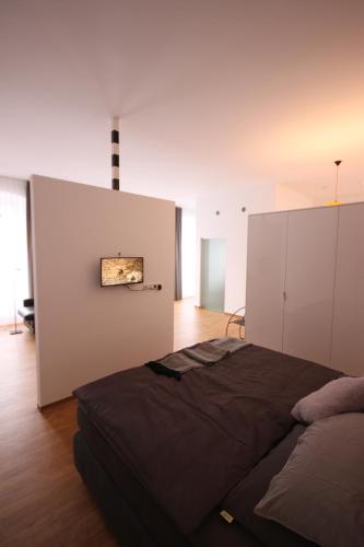 ein Schlafzimmer mit einem Bett und einer weißen Wand in der Unterkunft Moselloft Zeltingen-Rachtig in Zeltingen-Rachtig
