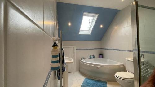 y baño con bañera, aseo y lavamanos. en Ivy Cottage Seahouses Seaside Hot Tub Retreat, en Seahouses