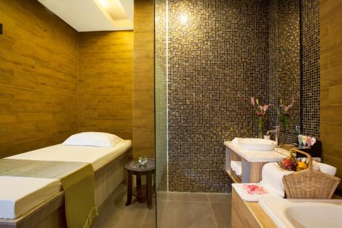 a bathroom with a bed and a tub and a sink at Best Western Premier The Hive in Jakarta