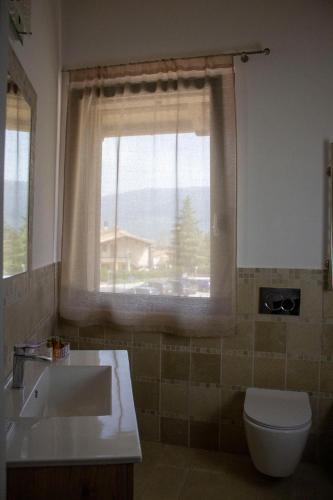 a bathroom with a sink and a toilet and a window at CENTO FIORI in Castel San Giovanni