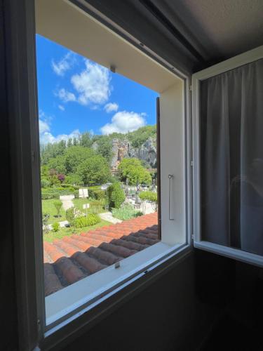 a window with a view of a roof at Hôtel Restaurant Les Falaises in Bouziès