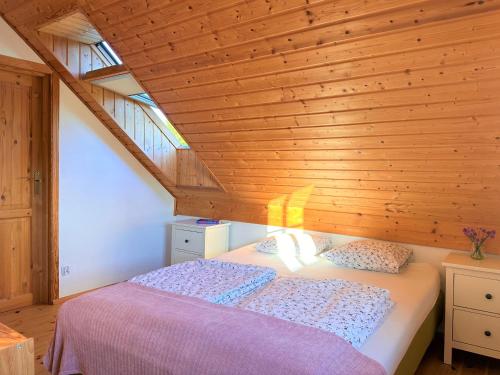 a bedroom with a bed with a wooden ceiling at Liwia Park in Niechorze