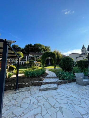 a patio with a stone walkway in a yard at Hôtel Restaurant Les Falaises in Bouziès