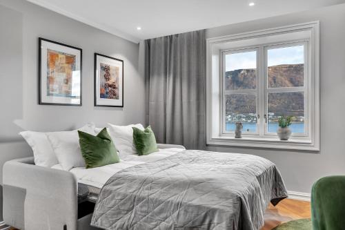 a bedroom with a bed and a chair and two windows at Enter St Elisabeth Suites & Spa in Tromsø