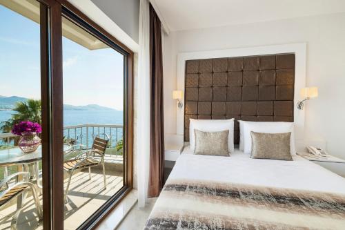 a bedroom with a large bed and a balcony at Elite Hotel Yalıkavak in Yalıkavak