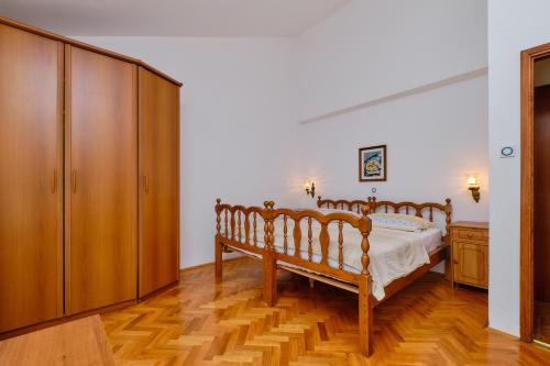 a bedroom with a bed and a wooden cabinet at Apartments Marija in Mali Lošinj