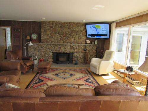 a living room with a couch and a stone fireplace at C-Scape in Boutiliers Point