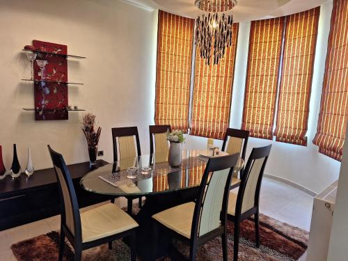 a dining room with a table and chairs and a chandelier at Villa Maria in Haraki