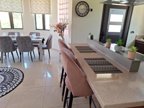 a dining room with a table and chairs and a clock at Villa Maria in Haraki
