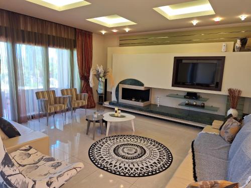 a living room with couches and a flat screen tv at Villa Maria in Haraki