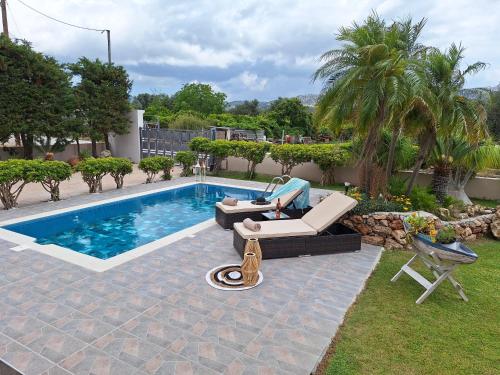 a person sitting on a couch next to a swimming pool at Villa Maria in Haraki