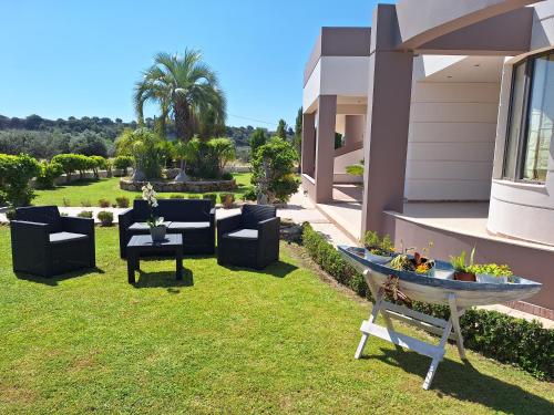 a garden with furniture and a table on the grass at Villa Maria in Haraki