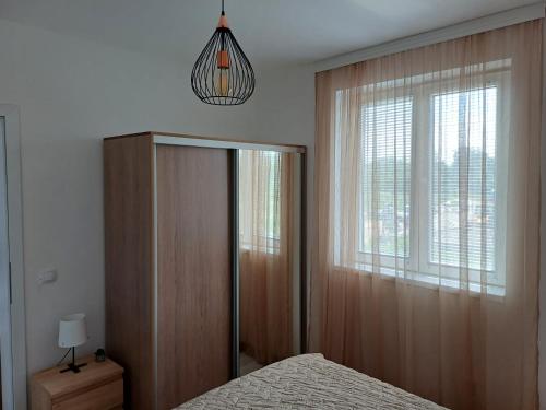 a bedroom with a bed and a window at Apartman Silver Lux Srebrno jezero in Veliko Gradište