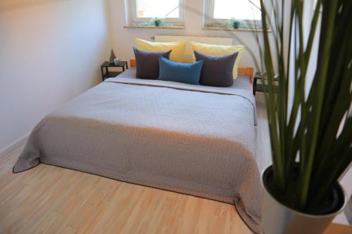 a bedroom with a bed with pillows and a plant at Watt´n Dog - Urlaub direkt am Nordseedeich in Spieka-Neufeld