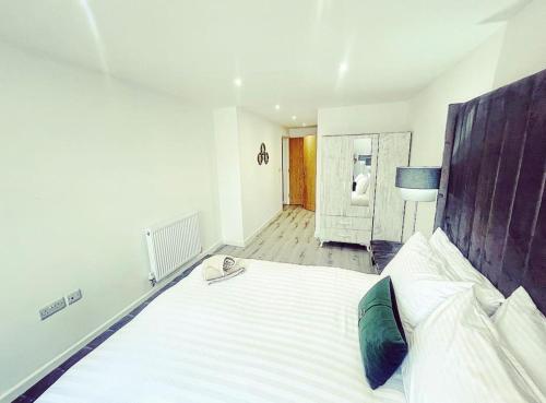 a bedroom with a large bed with a wooden headboard at Brand new The Elegant Abode Apartment 2 Bedrooms, 1 Minute walk to shops restaurants cafe supermarket and high street in Oxford