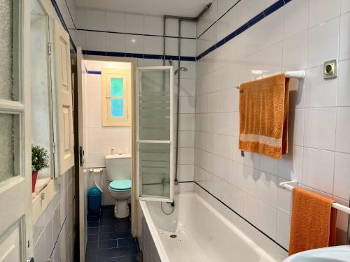a bathroom with a tub and a toilet and a sink at Casa do Sete in Vilar do Pinheiro