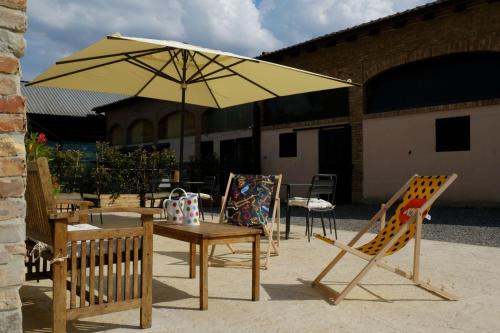 a table and chairs with a yellow umbrella at Agriturismo I Tre Colli -Rubbiano- in Viazzano