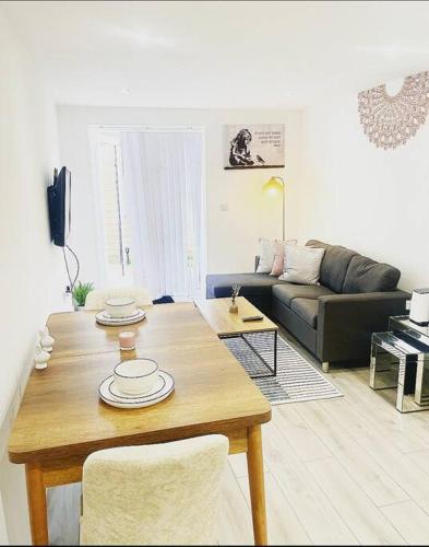 a living room with a table and a couch at Brand new The Elegant Abode Apartment 2 Bedrooms, 1 Minute walk to shops restaurants cafe supermarket and high street in Oxford