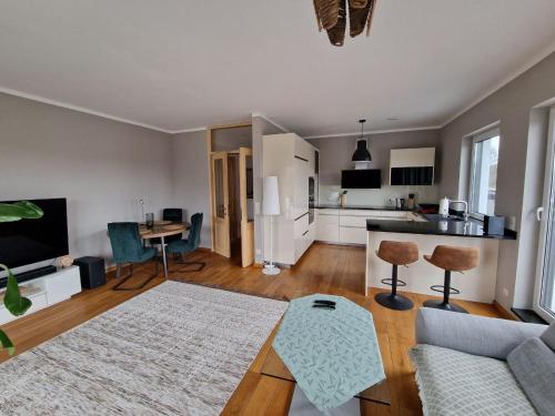 sala de estar con sofá, mesa y cocina en Luxuriöse 2-Zimmer-Wohnung mit Terrasse, Balkon und Wasserbett, en Garbsen