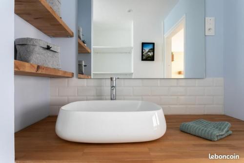 La salle de bains blanche est pourvue d'un lavabo et d'une baignoire. dans l'établissement Le p'tit Flaubert- Quartier Coty, au Havre