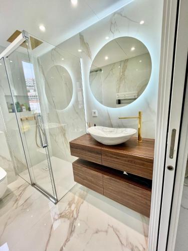 une salle de bain avec un lavabo et un miroir dans l'établissement Luxueux appartement aux portes de Monaco - CAP D AIL, à Cap d'Ail