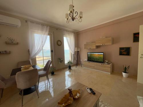 a living room with a television and a table at Sea view apartement in Durrës