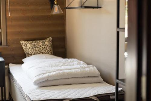 a bed with white sheets and a pillow on it at Orsa Grönklitt in Orsa