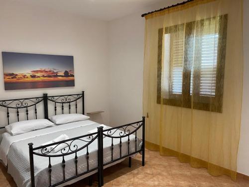 a bedroom with a black bed and a window at ZEFIRO in Marsala
