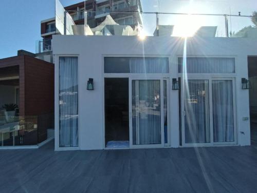 a white house with glass doors and a balcony at Q Conzept apt 2br new in Kata Beach