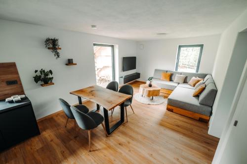 a living room with a couch and a table and chairs at Goat's Paradise in Bohinj