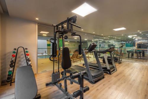 a gym with tread machines and a mirror at Hotel Laghetto Fratello in Gramado