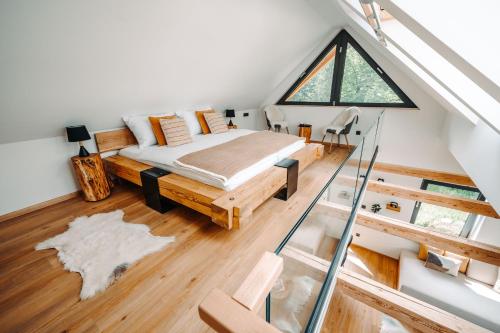 sypialnia na poddaszu z łóżkiem i oknem w obiekcie Goat's Paradise w Bohinju