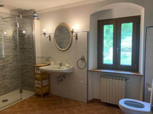 baño con lavabo y aseo y ventana en Holiday Home Villa il Cesto, en Greve in Chianti