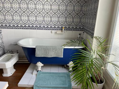a bathroom with a blue bath tub and a sink at les Pastoureaux in Orléans